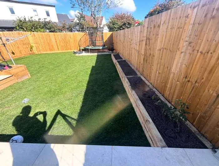 Garden fencing with timber sleeper raised beds and freshly laid turf