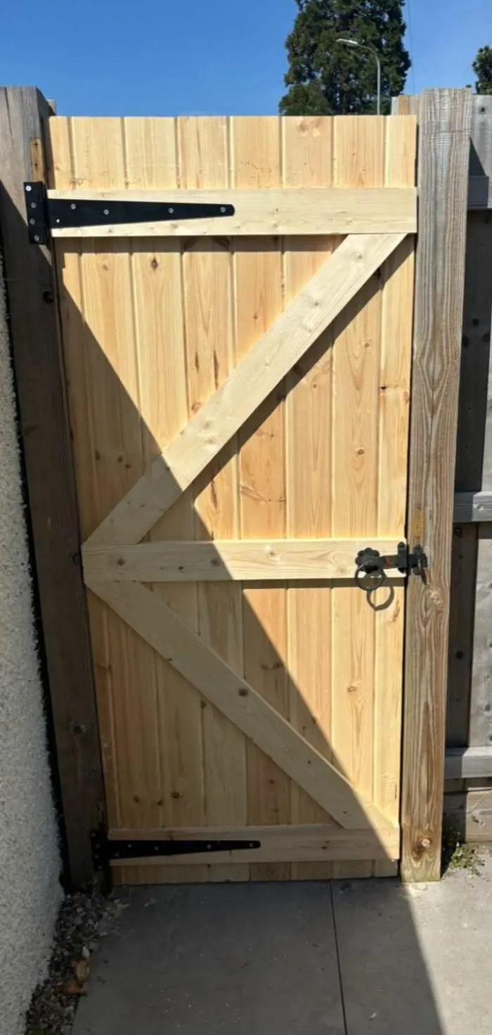 Framed timber side gate with black hinges and latch