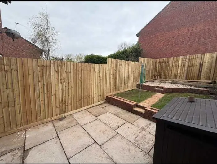 Stepped closeboard fencing on a terraced garden with patio